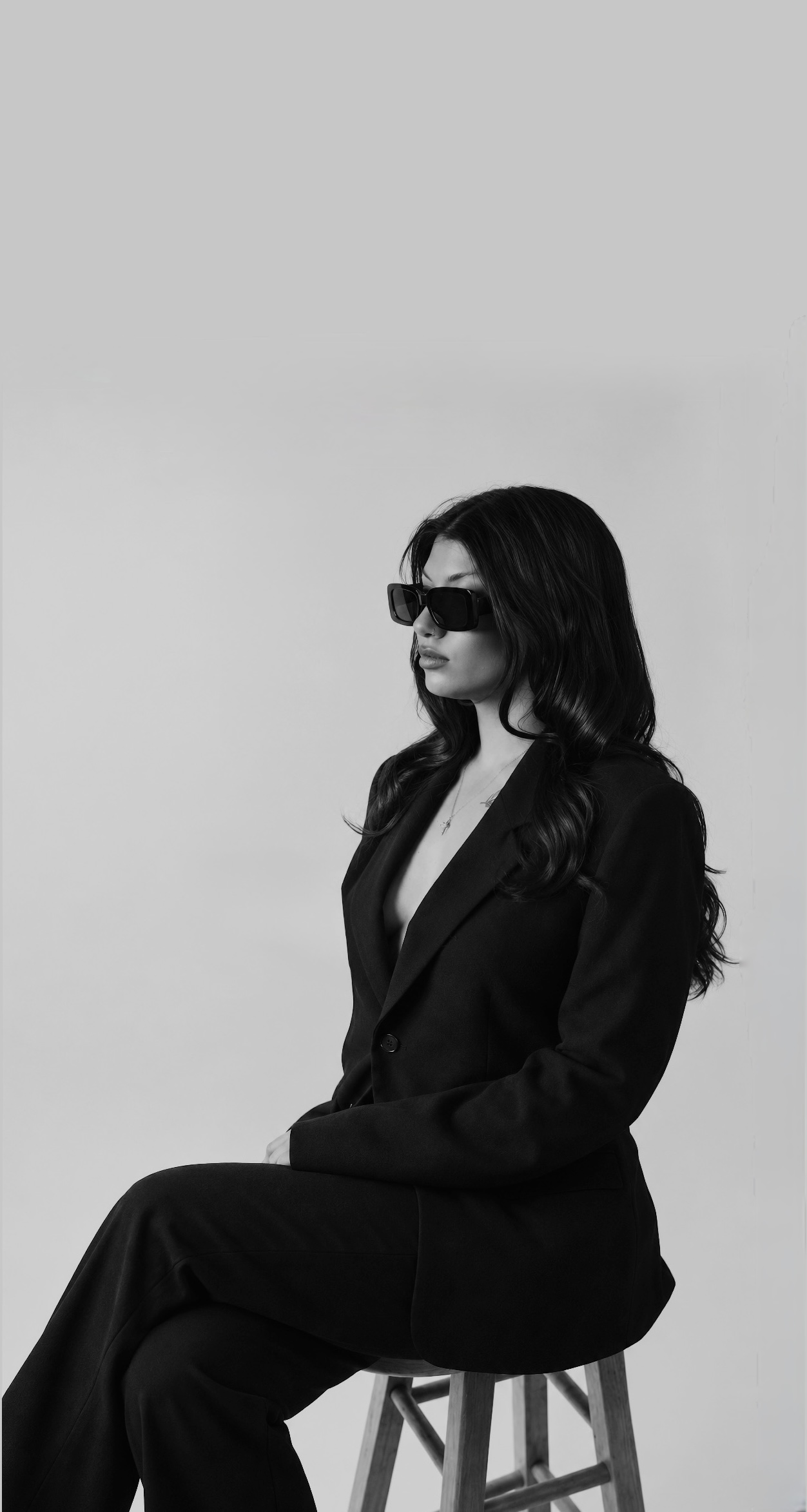 Lai seated in a black suit and sunglasses